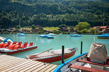 Boats and catamarans on the pier, boat rental for tourists on a lake. A picturesque place for a relaxing holiday.