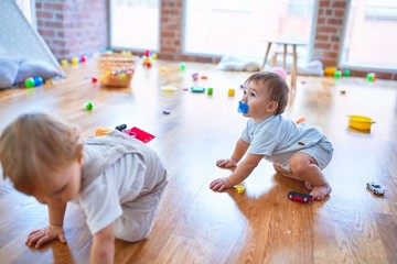 Beautiful toddlers playing around lots of toys at kindergarten