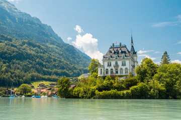 Schloss Seeburg. Seeburg castle was built on peninsula surrounded by the teal coloredwaters of lake Brienz. Iseltwald, Switzerland.