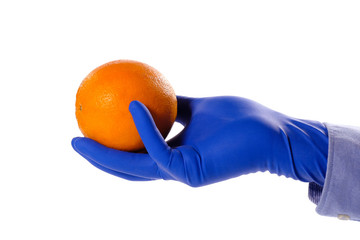 Ripe orange and hand in a blue rubber glove isolated on a white background.