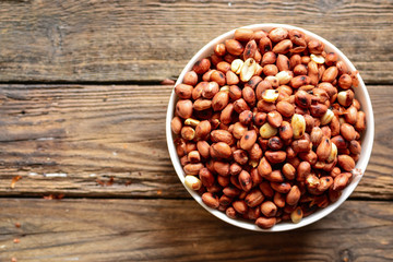 Roasted peanuts, salt, put in a cup. Brown was placed on the wooden floor.