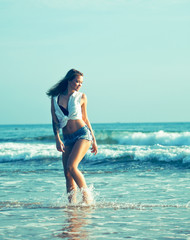 young pretty blond woman at seacoast walking relaxing, fashion lady at sunset, lifestyle people vacations concept