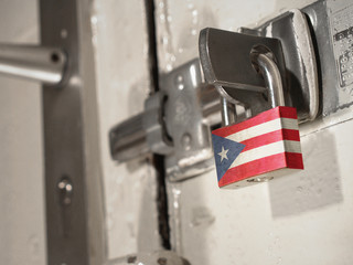 A bolted door secured by a padlock with the national flag of Puerto Rico on it.(series)