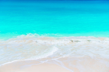 Idyllic tropical beach with white sand, turquoise ocean water and blue sky on Caribbean island