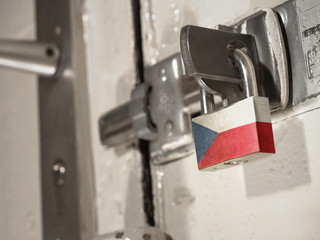 A bolted door secured by a padlock with the national flag of Czech Republic on it.(series)