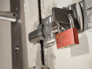 A bolted door secured by a padlock with the national flag of China on it.(series)