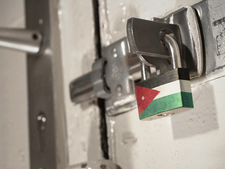 A bolted door secured by a padlock with the national flag of Jordan on it.(series)