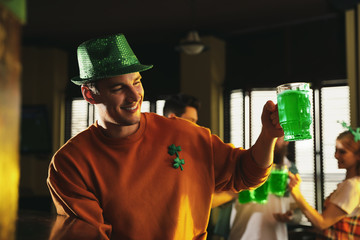 Man with glass of green beer in pub. St. Patrick's Day celebration