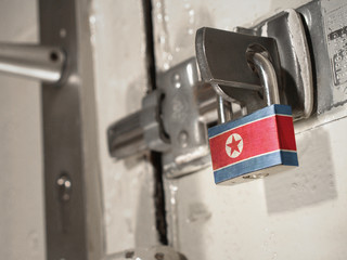 A bolted door secured by a padlock with the national flag of North Korea on it.(series)