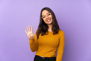 Young mixed race woman isolated on purple background happy and counting four with fingers