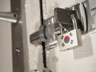 A bolted door secured by a padlock with the national flag of South Korea on it.(series)