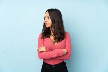 Young mixed race woman isolated on blue background portrait