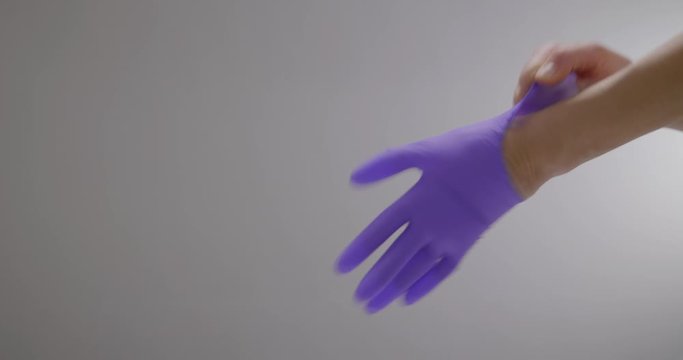 CU Of Human's Hands Slipping On Purple Gloves For Protection