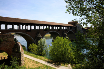 Fototapeta na wymiar Pavia (PV), Italy - June 09, 2018: The Ponte Coperto (covered bridge), also known as the Ponte Vecchio (old bridge), a brick and stone arch bridge over the Ticino River in Pavia, Lombardy, Italy