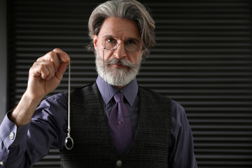 Psychotherapist with pendulum in office. Hypnotherapy session