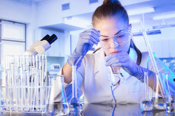Laboratory interior. Science research concept. Young scientist during experiment and using...