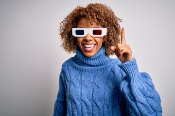 Young african american curly woman wearing 3d glasses over isolated white background pointing finger up with successful idea. Exited and happy. Number one.