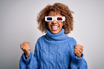 Young african american curly woman wearing 3d glasses over isolated white background very happy and excited doing winner gesture with arms raised, smiling and screaming for success. Celebration