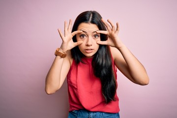 Obraz na płótnie Canvas Young brunette woman wearing casual summer shirt over pink isolated background Trying to open eyes with fingers, sleepy and tired for morning fatigue