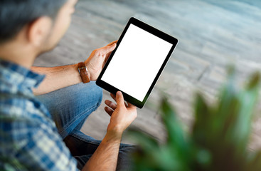 Mockup of a man holds tablet computer with isolated screen in his hands. View from above. Clipping...