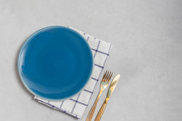Empty plate and kitchen textile napkin with silverwear