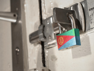 A bolted door secured by a padlock with the national flag of Eritrea on it.(series)