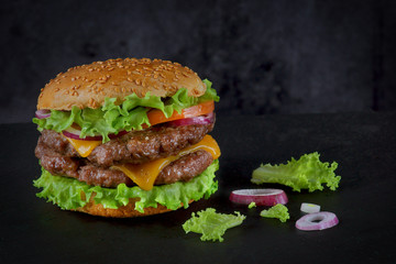 Burger with two beef patties and cheese on a dark background