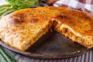 freshly baked cabbage pie on rustic wooden background
