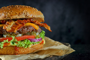 Burger with beef Patty, cheese and bacon on a dark background