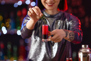 Female bartender with alcohol in pub
