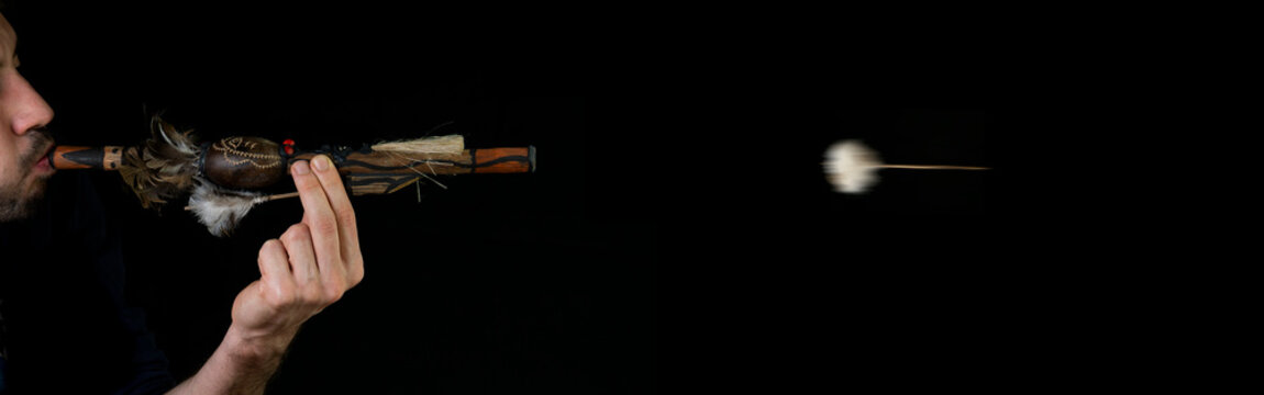 Blowpipe (blowgun) and darts from indegenous tribe of Amazon (near Manaus) isolated on black background