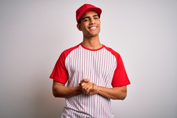 Young handsome african american sportsman wearing striped baseball t-shirt and cap with hands together and crossed fingers smiling relaxed and cheerful. Success and optimistic