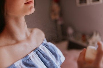 Naklejka premium The caucasian girl sprays perfume on her neck