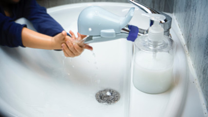 Unfocused background photo of father is washing hands of his baby toddler with soap for corona virus prevention, hygiene to stop spreading coronavirus. 