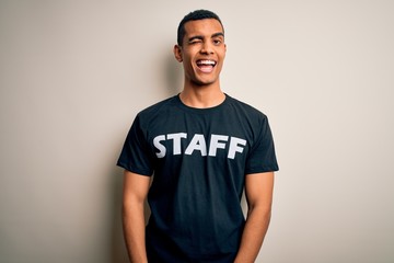 Young handsome african american worker man wearing staff uniform over white background winking...