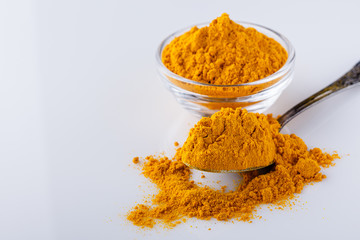 natural turmeric powder on white acrylic background