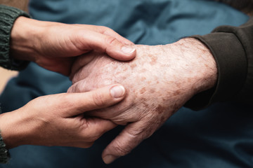 Le mani di una donna danno forza e conforto e quelle di un anziano signore