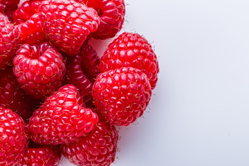 Juicy fresh natural raspberries on white acrylic background