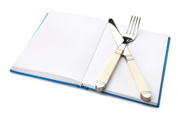 Cook book with cutlery on white background