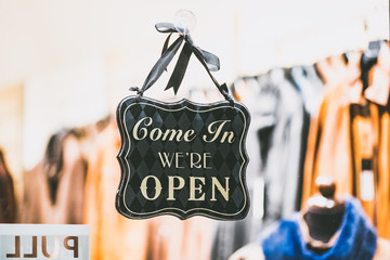 Panneau suspendu sur une devanture Come In We're Open
