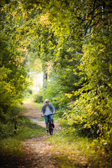 Obraz premium Joyful boy on a bicycle with his parents in the park