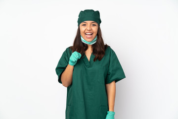 Surgeon woman in green uniform isolated on white background surprised and pointing front