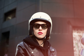 Close-up portrait of biker girl wearing white helmet. Outdoor. 