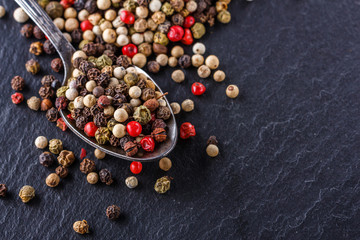 mix of peppercorns on a dark stone background