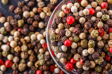 mix of peppercorns on a dark stone background