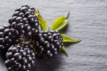 juicy fresh blackberries on dark stone background