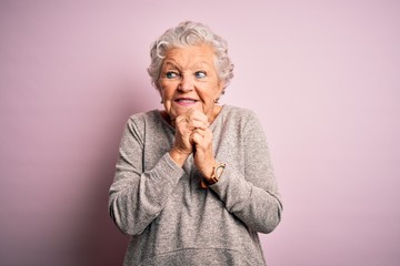 Senior beautiful woman wearing casual t-shirt standing over isolated pink background laughing...