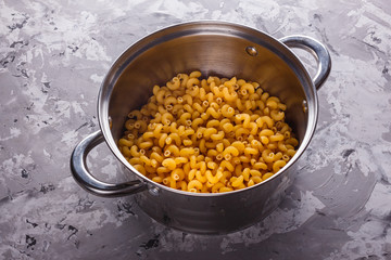Traditional Italian pasta in a metal pan on a stone background