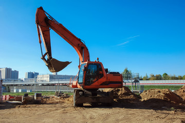 excavator at work against blue sky