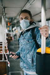 Man in the mask going to work on a tram